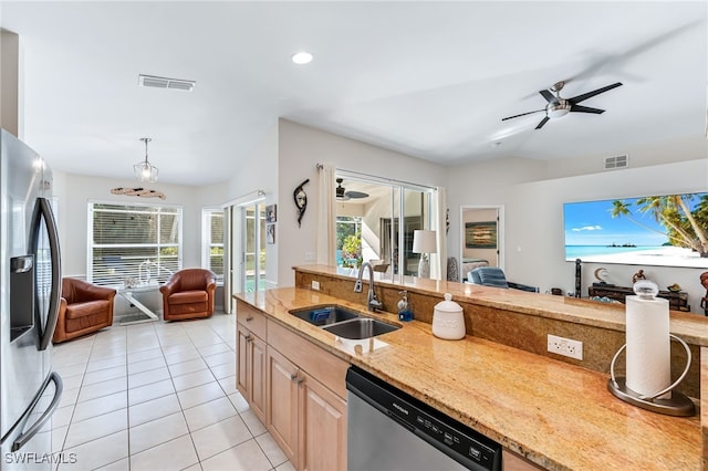 kitchen featuring a sink, open floor plan, stainless steel appliances, light tile patterned flooring, and ceiling fan