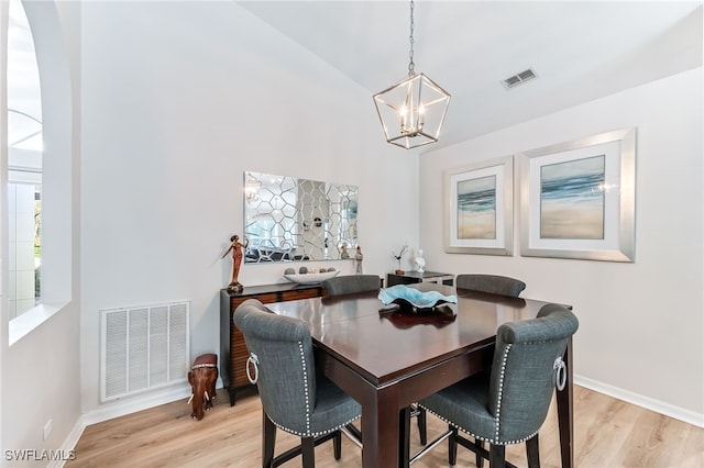 dining room with light wood-type flooring, visible vents, and a notable chandelier