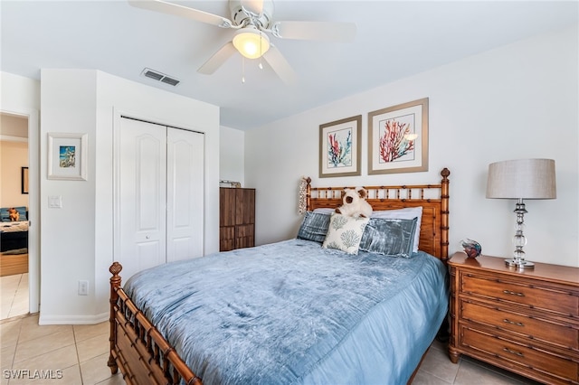 bedroom featuring light tile patterned floors, a ceiling fan, visible vents, baseboards, and a closet