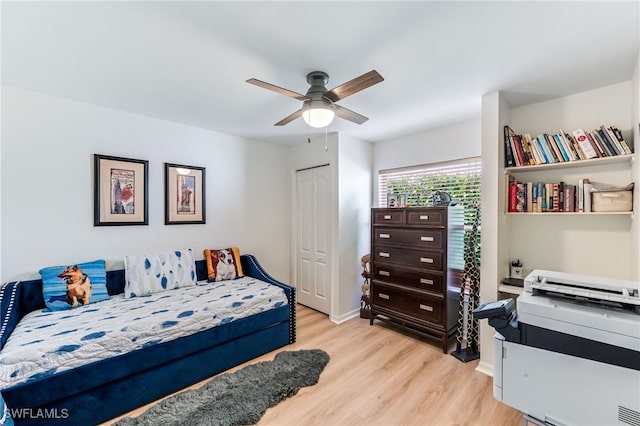 bedroom with a ceiling fan, a closet, light wood finished floors, and baseboards