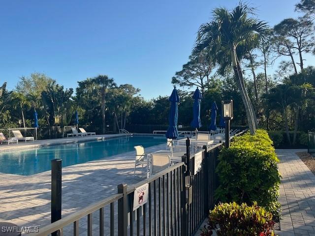 pool with a patio area and fence