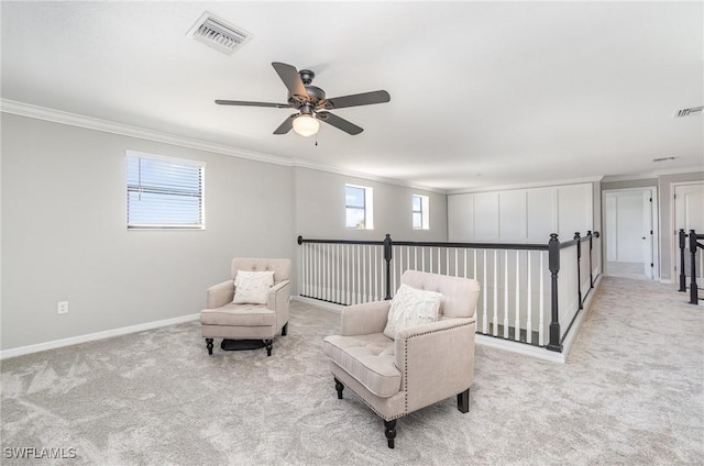living area with carpet flooring, a ceiling fan, visible vents, and ornamental molding