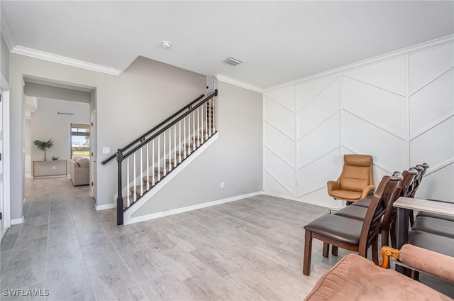 sitting room with visible vents, light wood finished floors, ornamental molding, and stairway