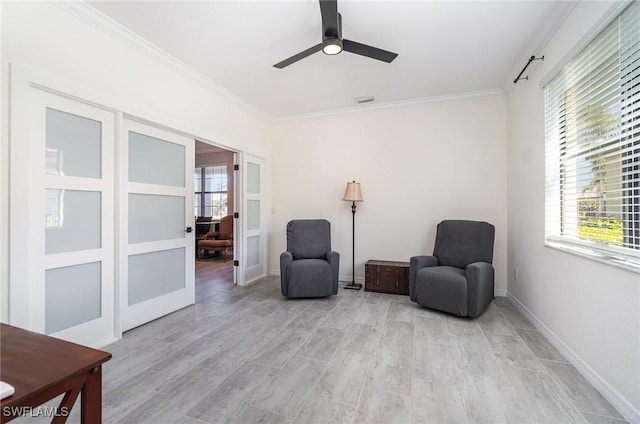 living area featuring baseboards, light wood-style flooring, ceiling fan, ornamental molding, and french doors