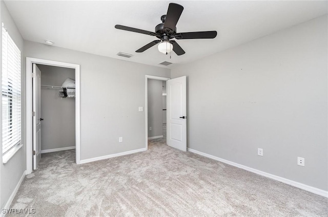 unfurnished bedroom featuring visible vents, carpet floors, baseboards, and a spacious closet