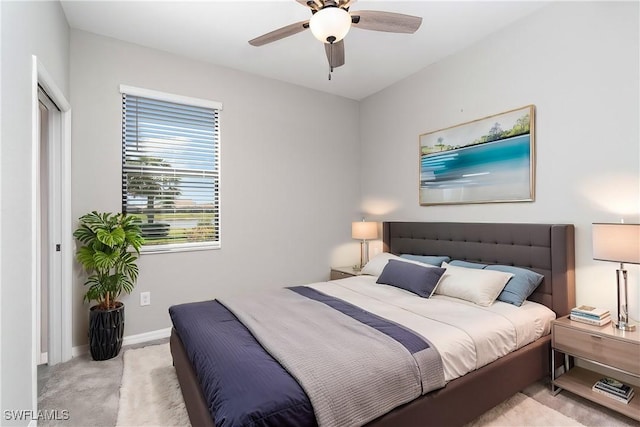 carpeted bedroom with ceiling fan and baseboards