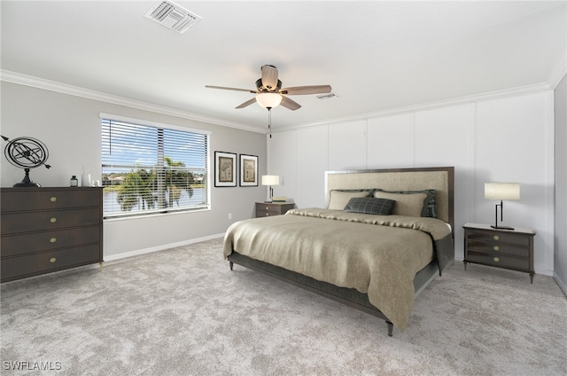 carpeted bedroom featuring visible vents, a ceiling fan, crown molding, and baseboards