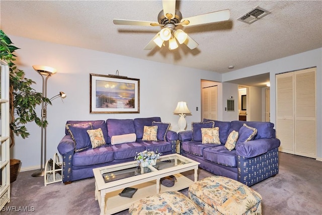 carpeted living room featuring visible vents, a textured ceiling, and a ceiling fan