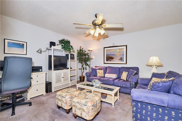 living area featuring carpet, ceiling fan, and a textured ceiling