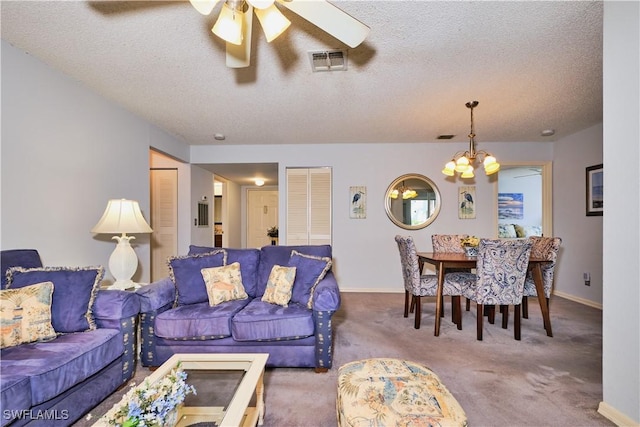 living room with visible vents, ceiling fan with notable chandelier, a textured ceiling, carpet floors, and baseboards