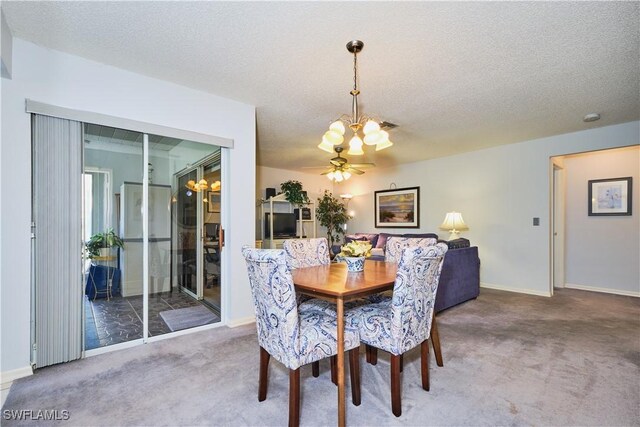 carpeted dining area with a notable chandelier, baseboards, and a textured ceiling