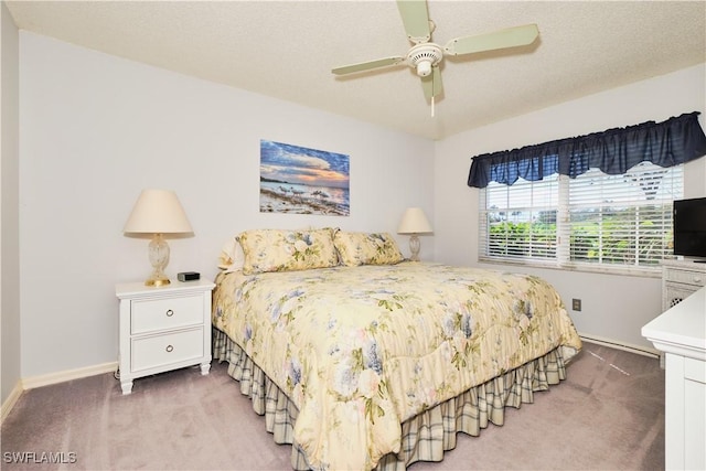 bedroom with carpet flooring, a textured ceiling, a ceiling fan, and baseboards