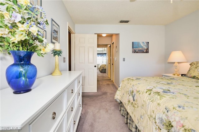 carpeted bedroom featuring visible vents and a textured ceiling