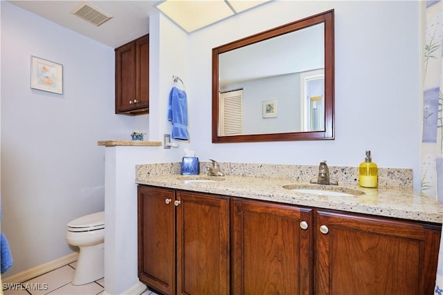 bathroom with a sink, visible vents, toilet, and double vanity