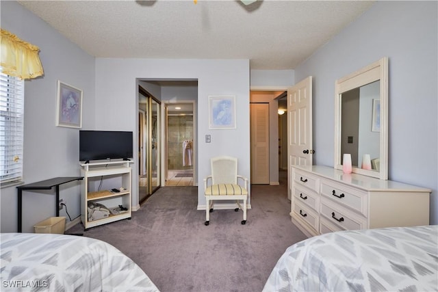 bedroom with dark colored carpet, connected bathroom, and a textured ceiling