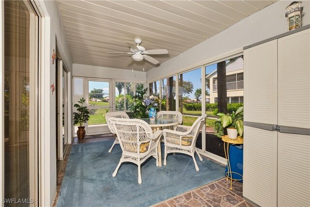 unfurnished sunroom featuring a ceiling fan