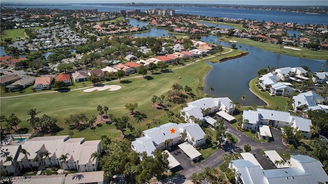 drone / aerial view with view of golf course, a water view, and a residential view