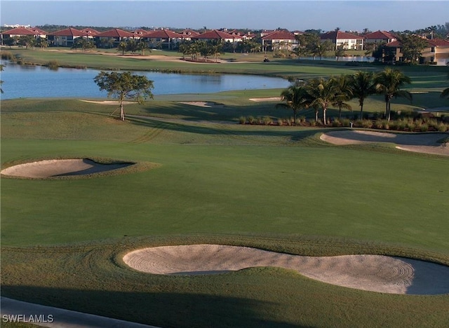 view of community featuring view of golf course, a lawn, a water view, and a residential view