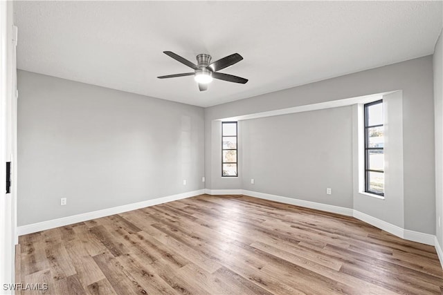 spare room featuring a ceiling fan, baseboards, and wood finished floors