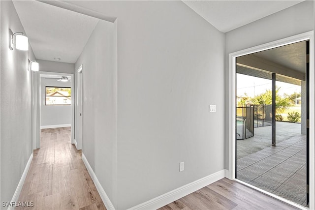 hall with baseboards and light wood-style floors