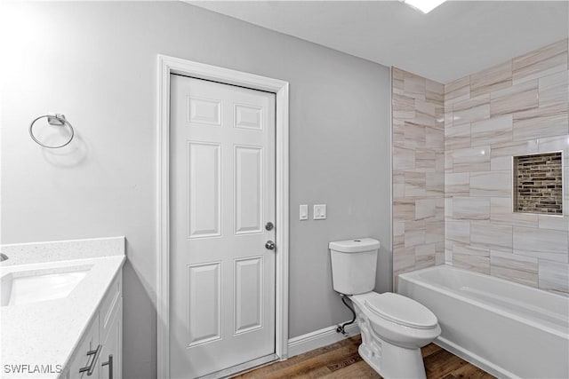 full bathroom featuring baseboards, toilet, wood finished floors, and vanity