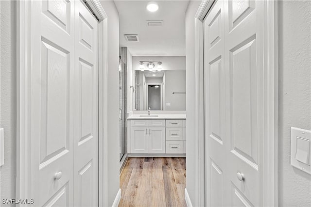 full bathroom with a closet, visible vents, wood finished floors, and vanity