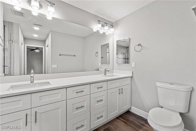 bathroom featuring a sink, visible vents, toilet, and a shower stall