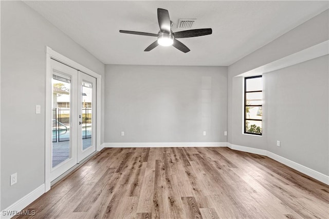 unfurnished room featuring visible vents, baseboards, and wood finished floors