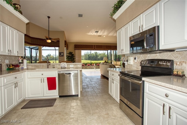 kitchen with visible vents, a sink, appliances with stainless steel finishes, white cabinets, and decorative backsplash