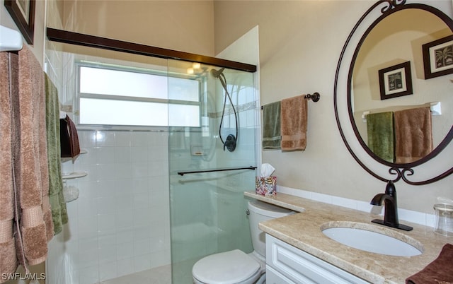 bathroom with vanity, a shower stall, and toilet