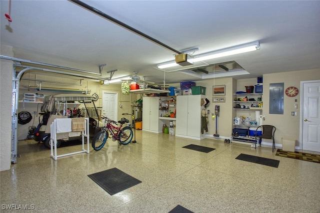 garage featuring electric panel, baseboards, and a garage door opener