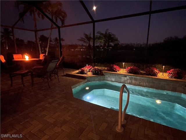 pool at twilight featuring a lanai, a patio area, an in ground hot tub, and a fire pit