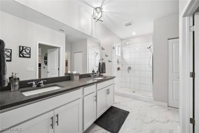 full bath with a sink, marble finish floor, a stall shower, and double vanity