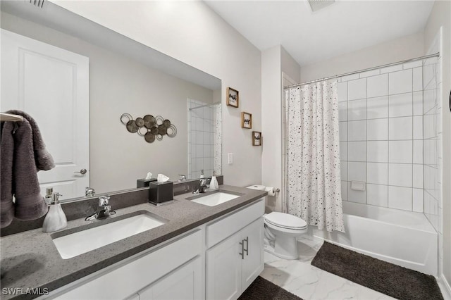 full bath with double vanity, marble finish floor, toilet, and a sink