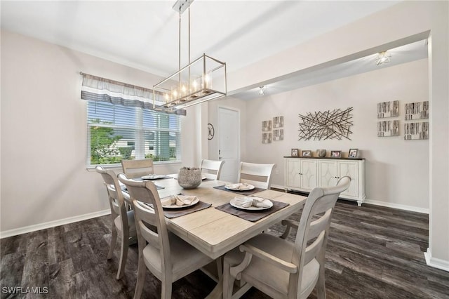 dining area with baseboards, dark wood-type flooring, and a chandelier