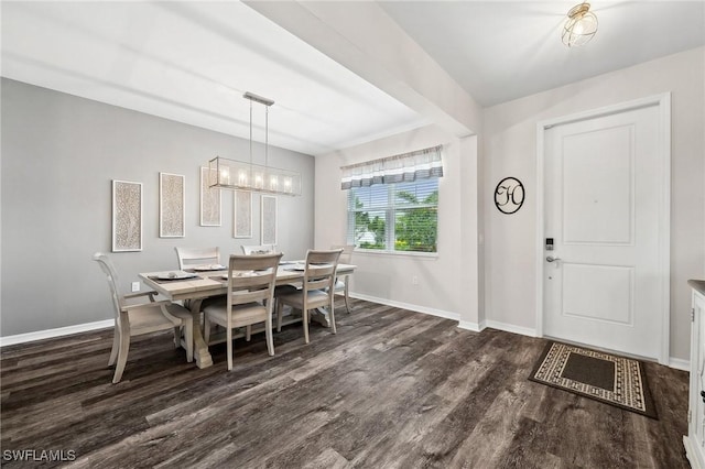 dining space featuring an inviting chandelier, baseboards, and wood finished floors