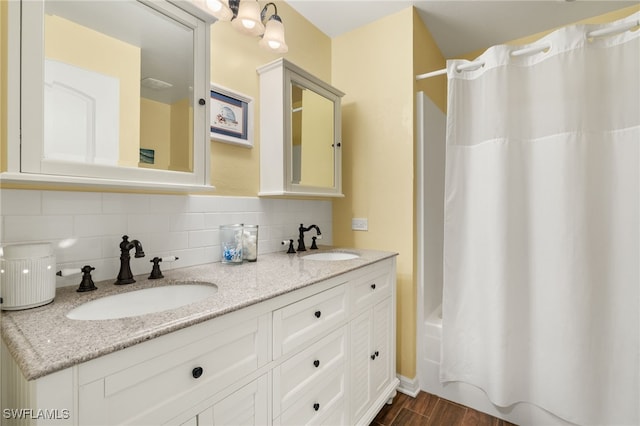 bathroom featuring a sink, shower / bathtub combination with curtain, backsplash, and wood finished floors