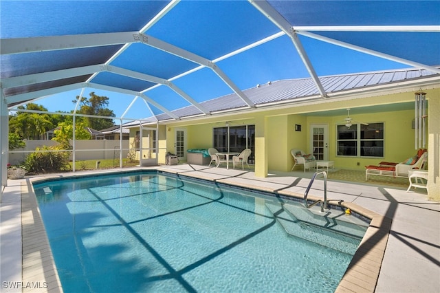 view of swimming pool featuring a ceiling fan, fence, a fenced in pool, a lanai, and a patio area