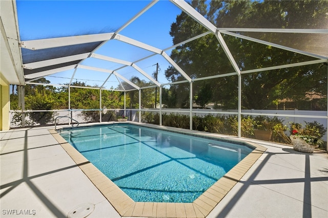 outdoor pool with glass enclosure and a patio area