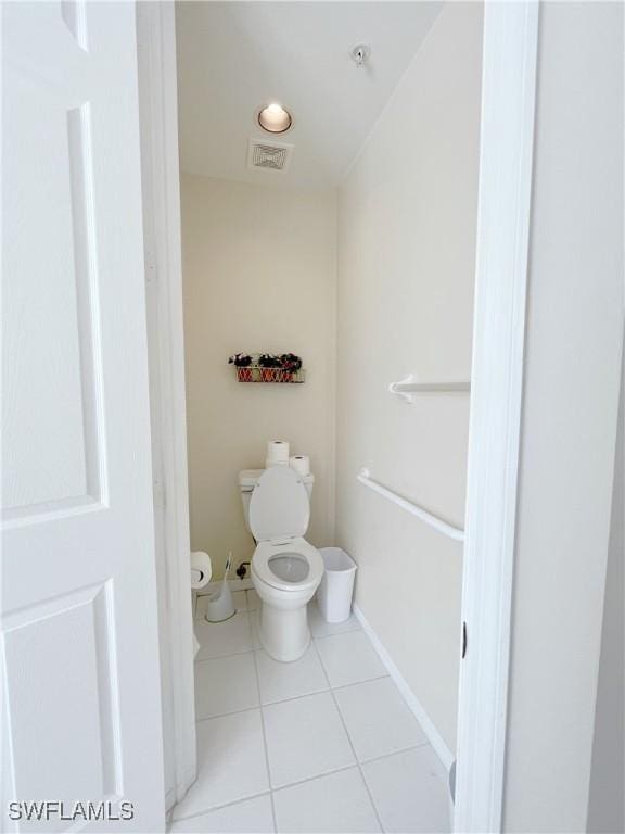 bathroom featuring toilet, baseboards, visible vents, and tile patterned flooring