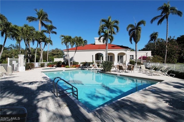 pool featuring fence and a patio area