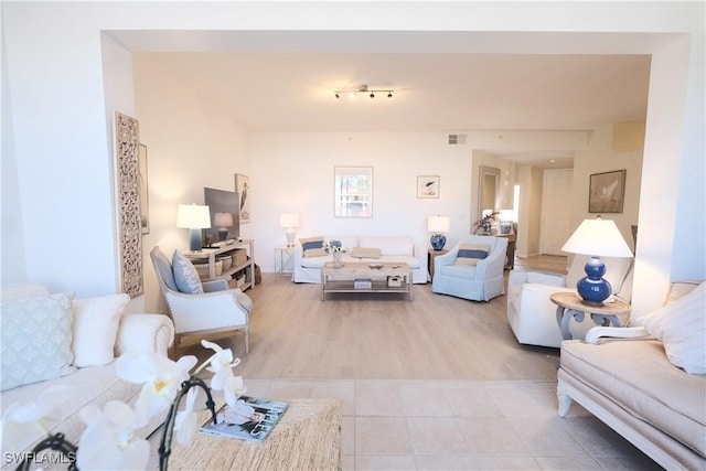 living area featuring light tile patterned floors and visible vents