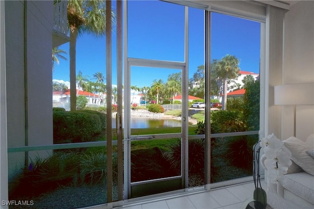 doorway to outside with a water view and tile patterned flooring