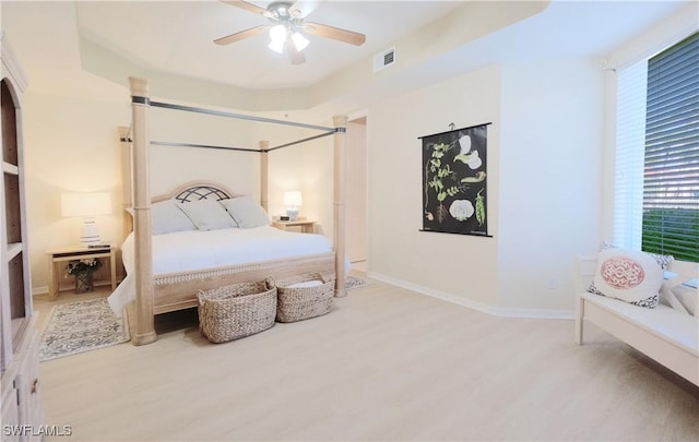 bedroom featuring visible vents, baseboards, ceiling fan, and wood finished floors