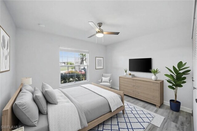 bedroom with baseboards, light wood-style floors, and ceiling fan