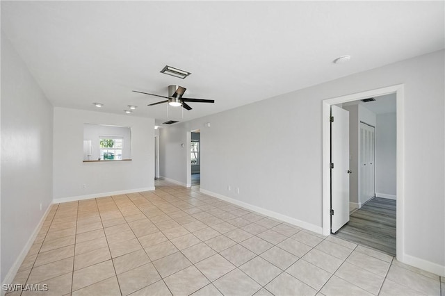 unfurnished room featuring light tile patterned floors, visible vents, baseboards, and ceiling fan