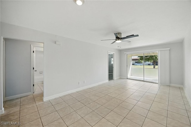 spare room with light tile patterned floors, baseboards, and a ceiling fan