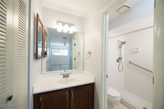 bathroom featuring vanity, toilet, visible vents, and tiled shower