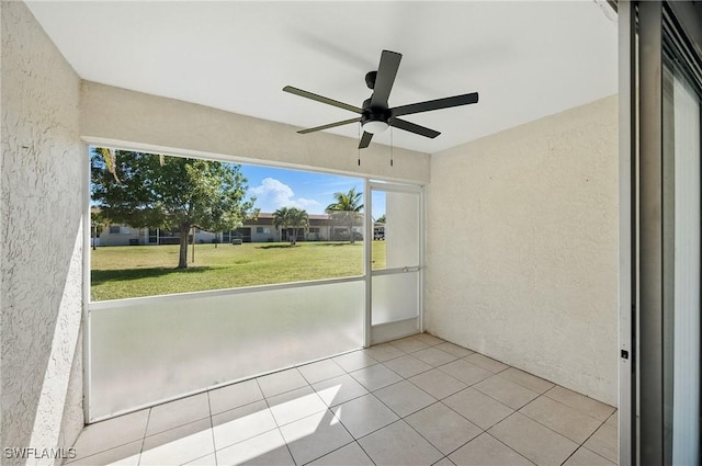 unfurnished sunroom featuring ceiling fan