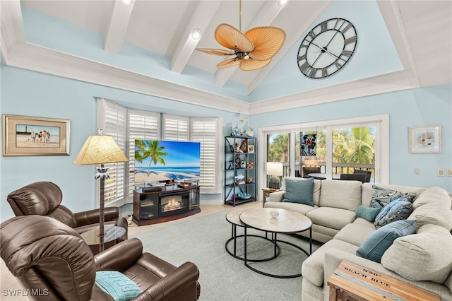 living area featuring ceiling fan, beamed ceiling, high vaulted ceiling, and a glass covered fireplace